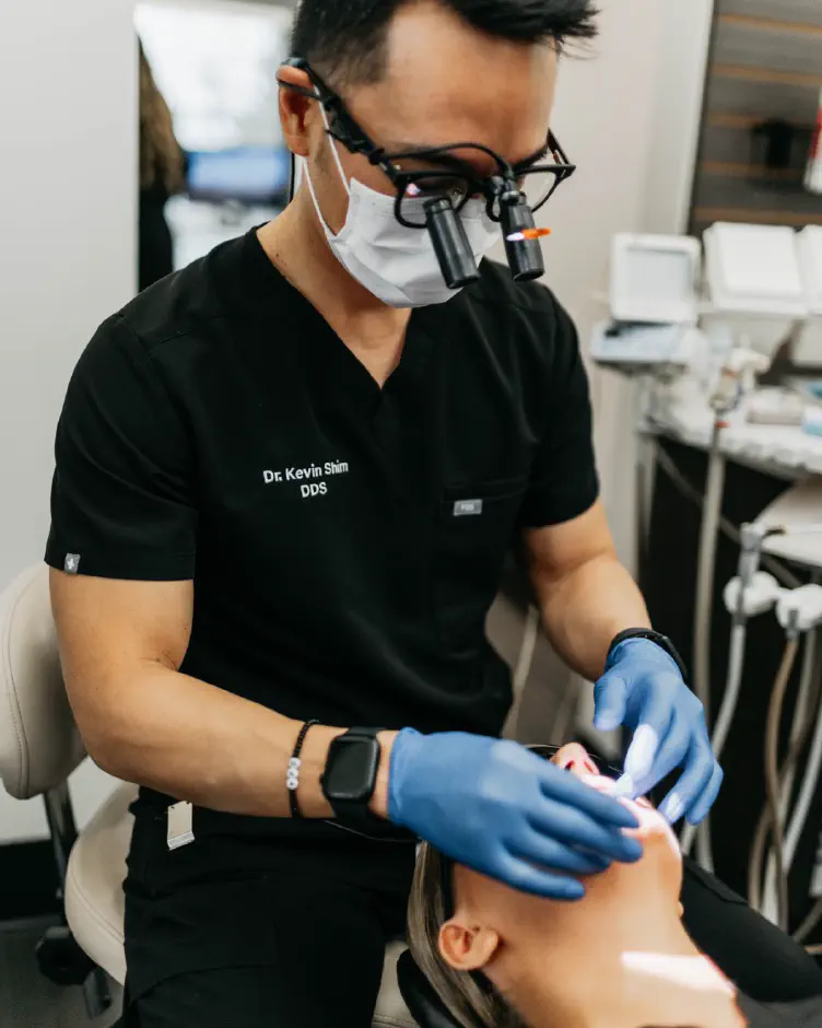 Dr. Kevin Shim, DDS, examining a patient at Premier Dentistry in Gresham, OR