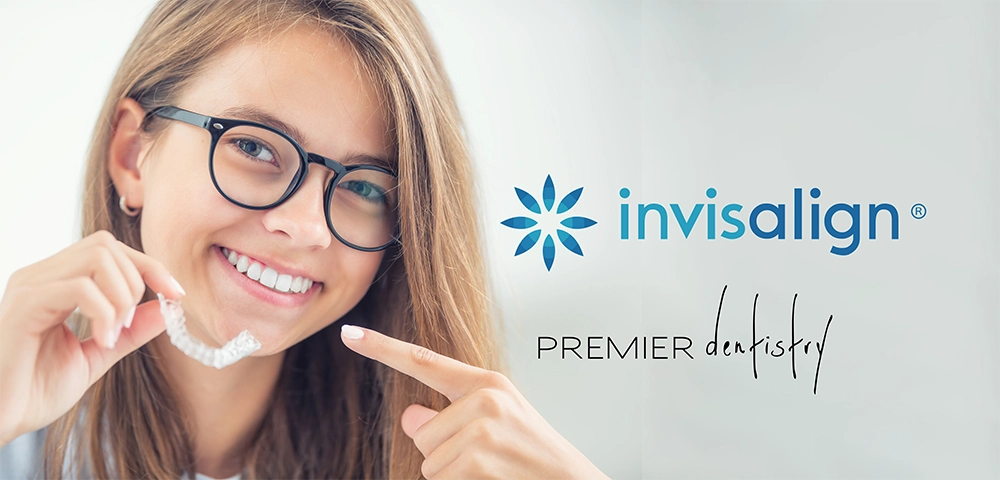 A woman holding invisalign clear aligner and pointing to it