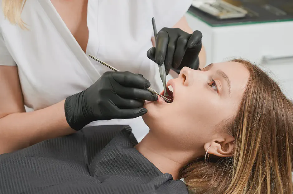A Hygienist examining patient teeth in dental office