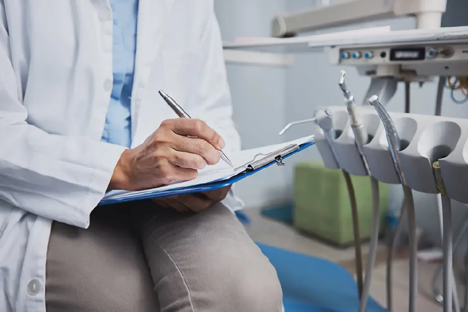 A Hygienist examining patient teeth in dental office