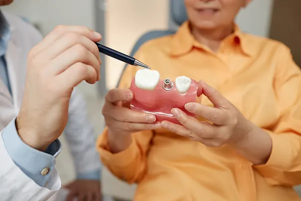 Dental crown on model with tools in background.